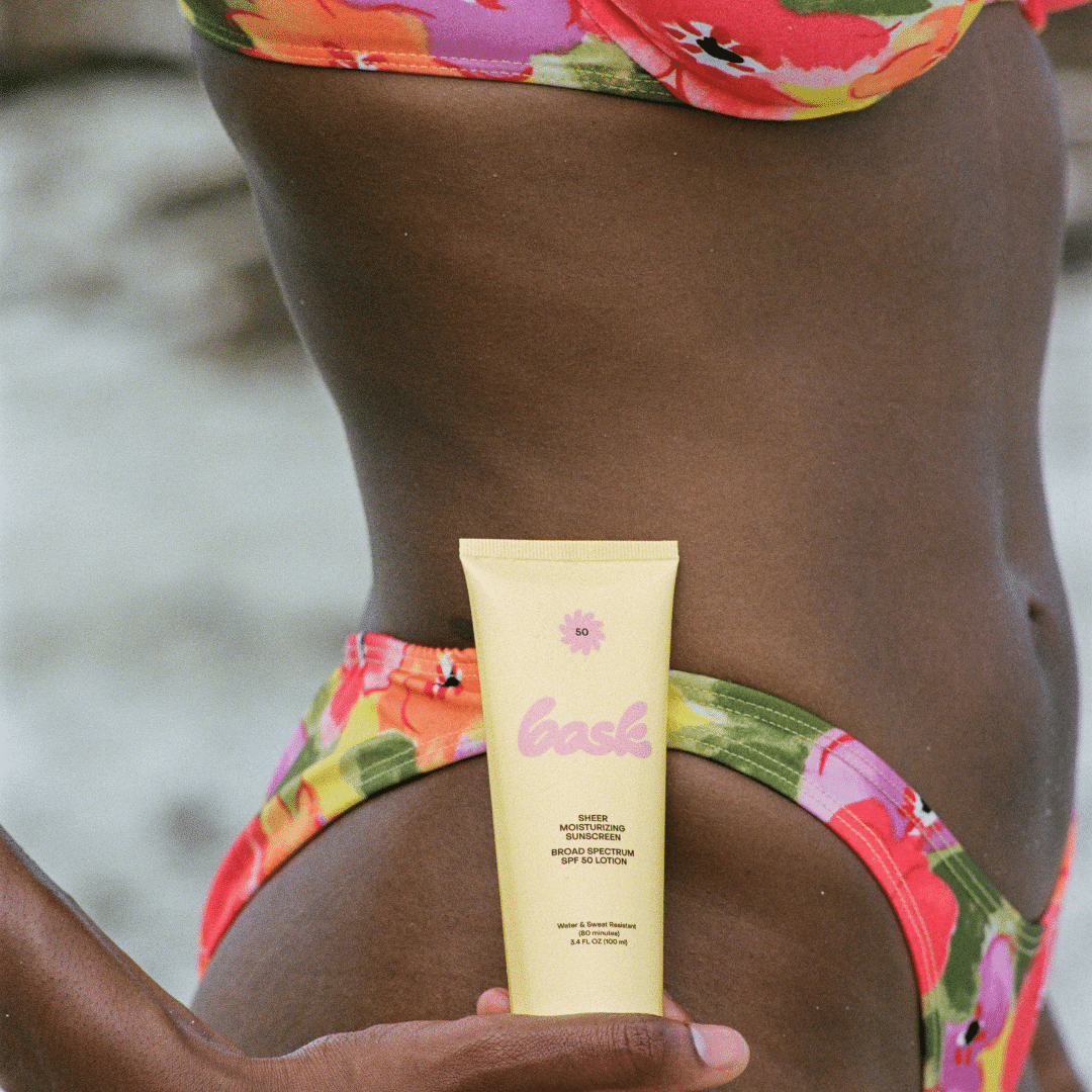 Woman Holding Bottle of Non Toxic Vegan Sunscreen at Her Hip